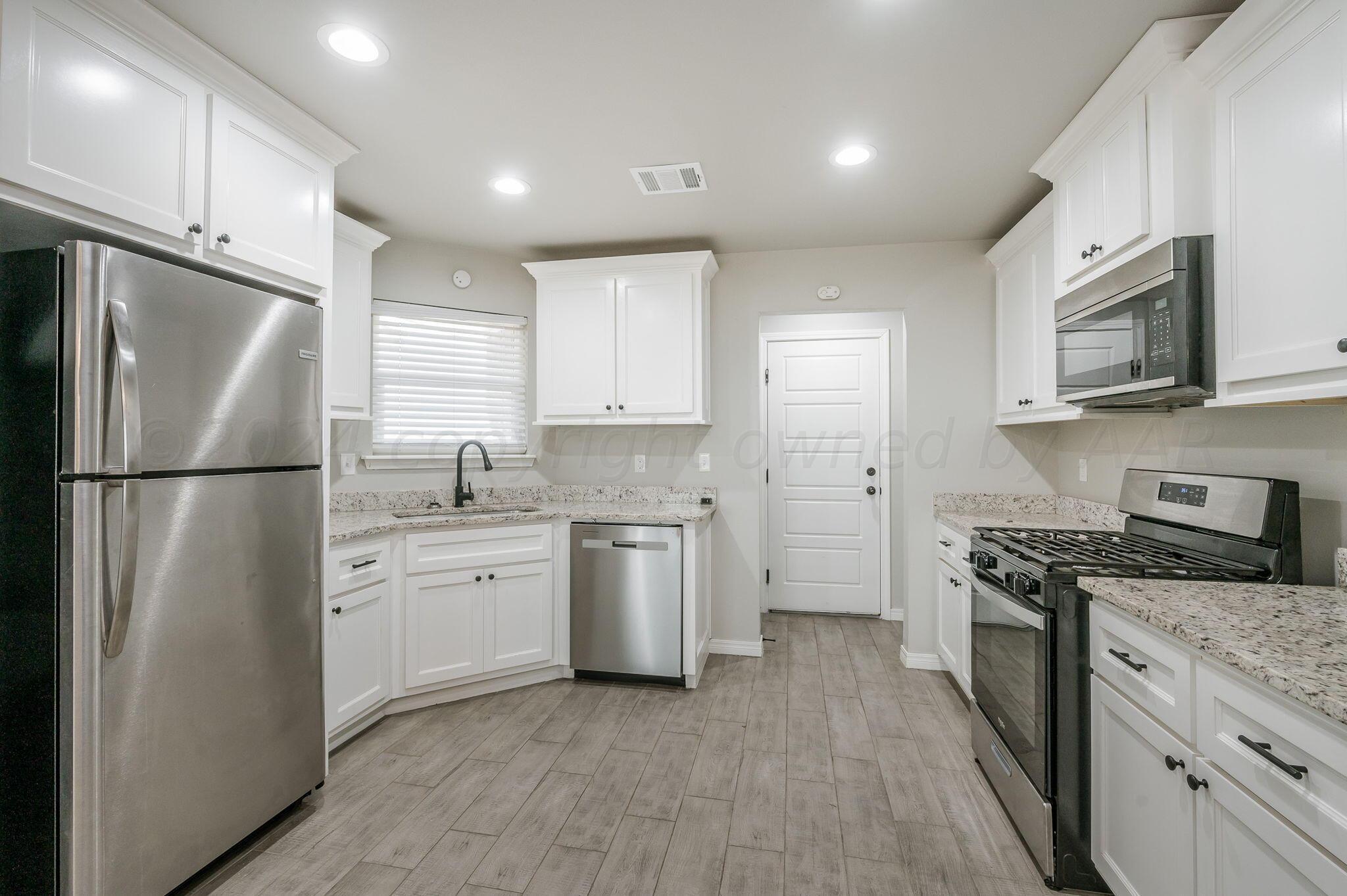13987 Periwinkle Drive, Unit 1 Amarillo, TX 79119 - Photo 7 of 20 a kitchen with a refrigerator stove and microwave