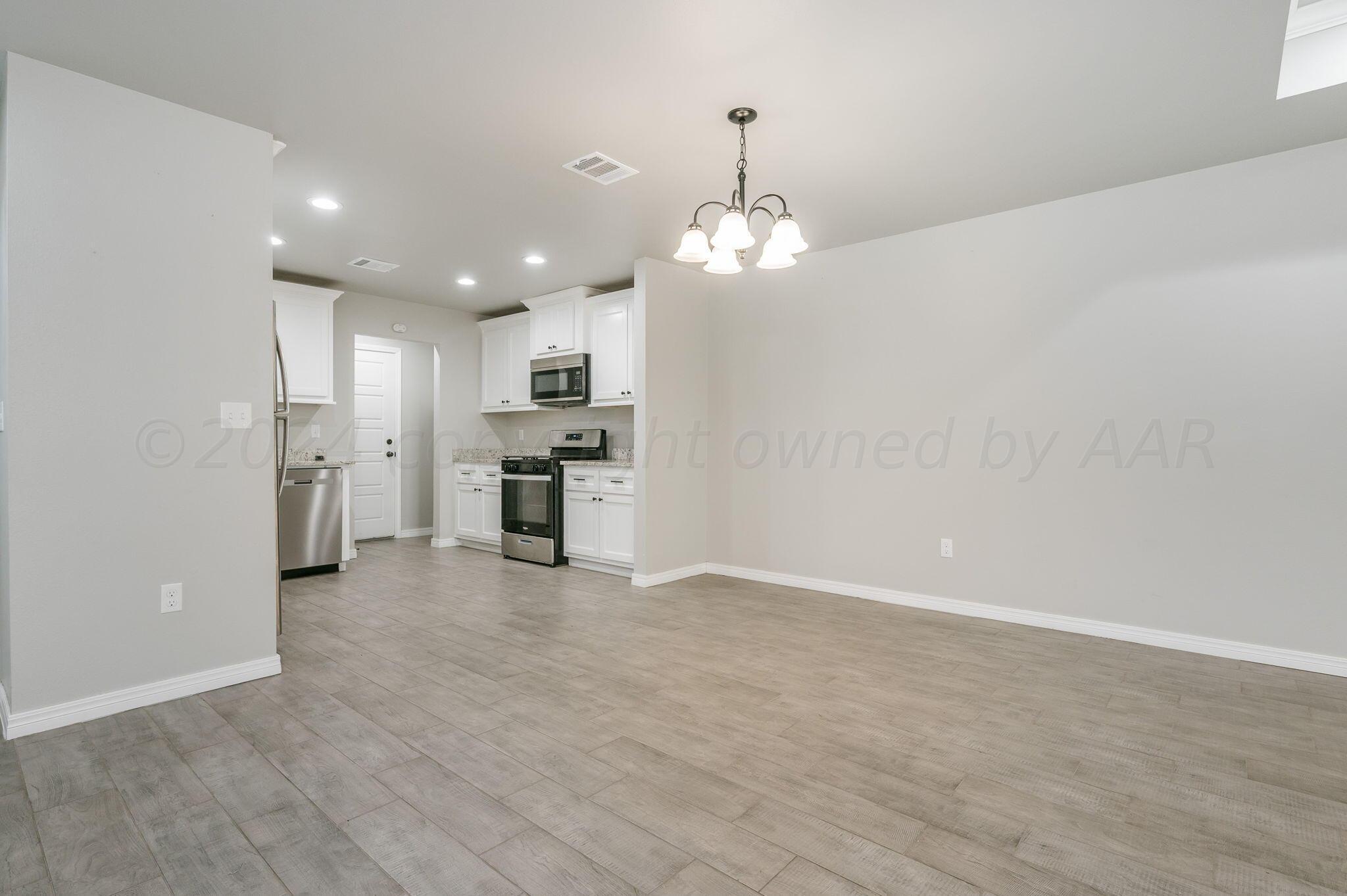 13987 Periwinkle Drive, Unit 1 Amarillo, TX 79119 - Photo 10 of 20 a view of a kitchen with a sink and dishwasher a refrigerator with white cabinets
