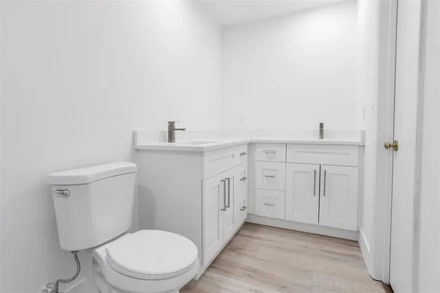 a bathroom with a toilet a sink a vanity and mirror