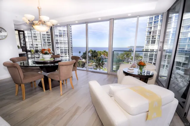 a dining room with furniture a chandelier and wooden floor