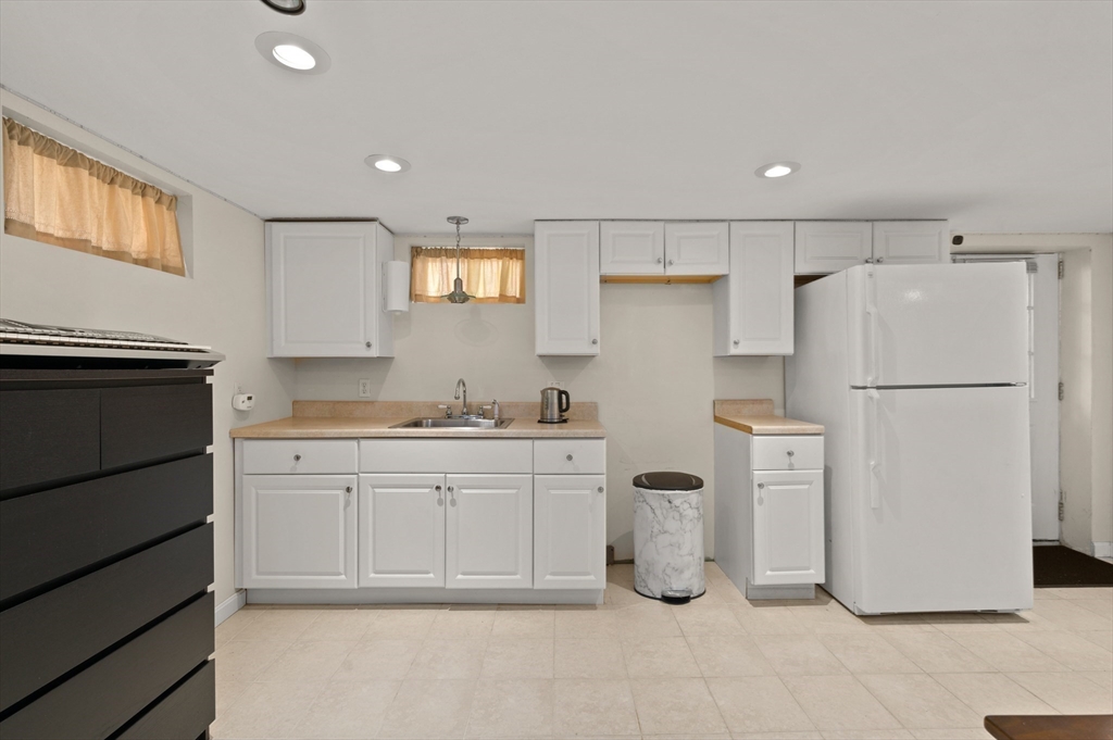 3 Athens Drive Saugus, MA 01906 - Photo 21 of 33 a kitchen with a sink a refrigerator and white cabinets