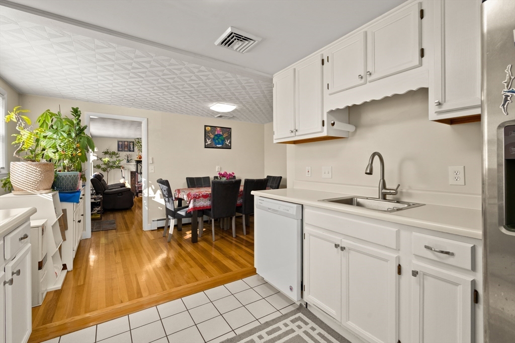 3 Athens Drive Saugus, MA 01906 - Photo 3 of 33 a kitchen with white cabinets sink and chairs