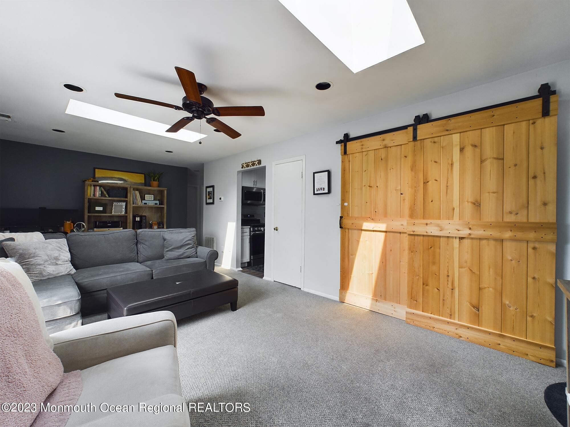 a living room with furniture a ceiling fan and a window