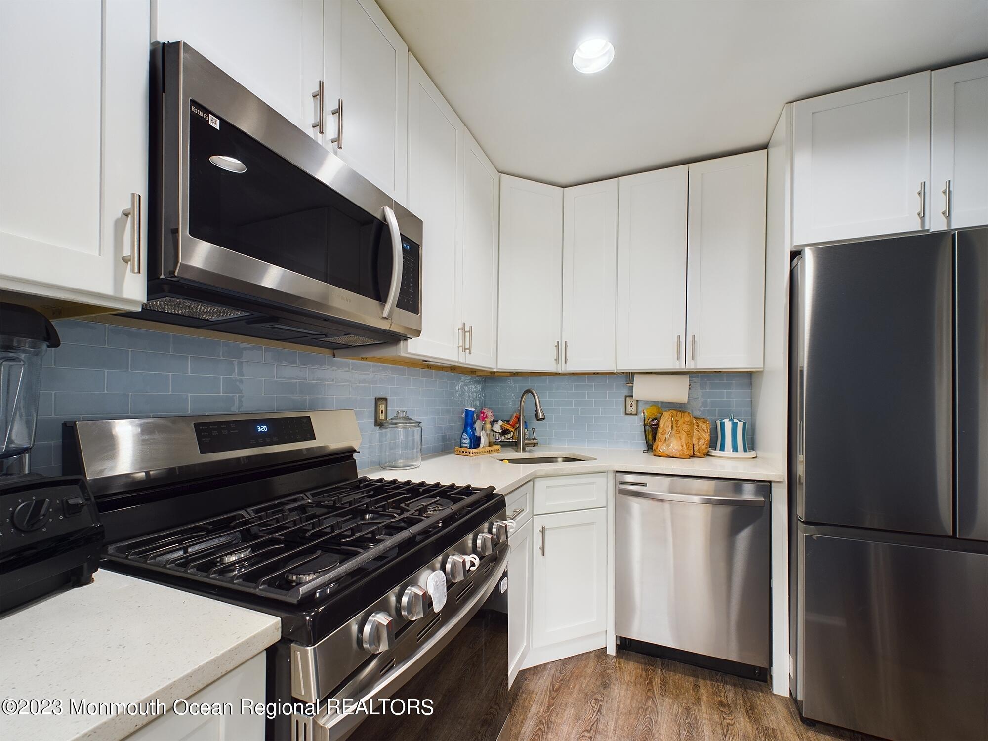 1606 Main Street, Unit F304 Belmar, NJ 07719 - Photo 3 of 9 a kitchen with stainless steel appliances a stove a microwave and cabinets