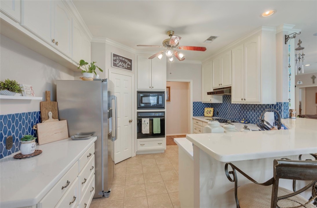 1400 Gun And Rod Road Brenham, TX 77833 - Photo 6 of 23 a kitchen with kitchen island a sink stove and refrigerator