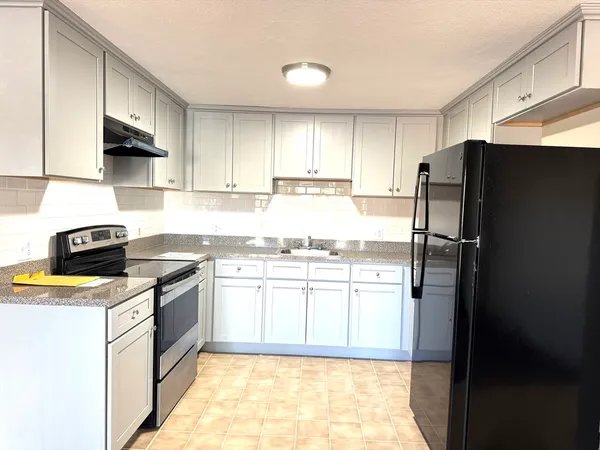 a kitchen with stainless steel appliances granite countertop a refrigerator stove and sink
