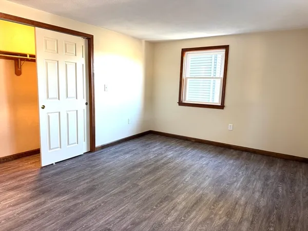 an empty room with wooden floor and a window