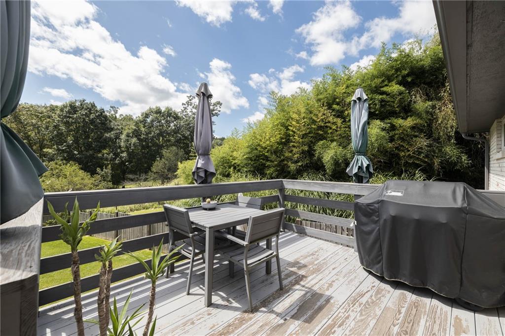 1420 Reissing Road McDonald, PA 15057 - Photo 22 of 33 A serene back deck with clean lines and natural wood tones, accented by lush greenery and simple planters. The space feels open and uncluttered inviting relaxation with its modern design that blends with nature.