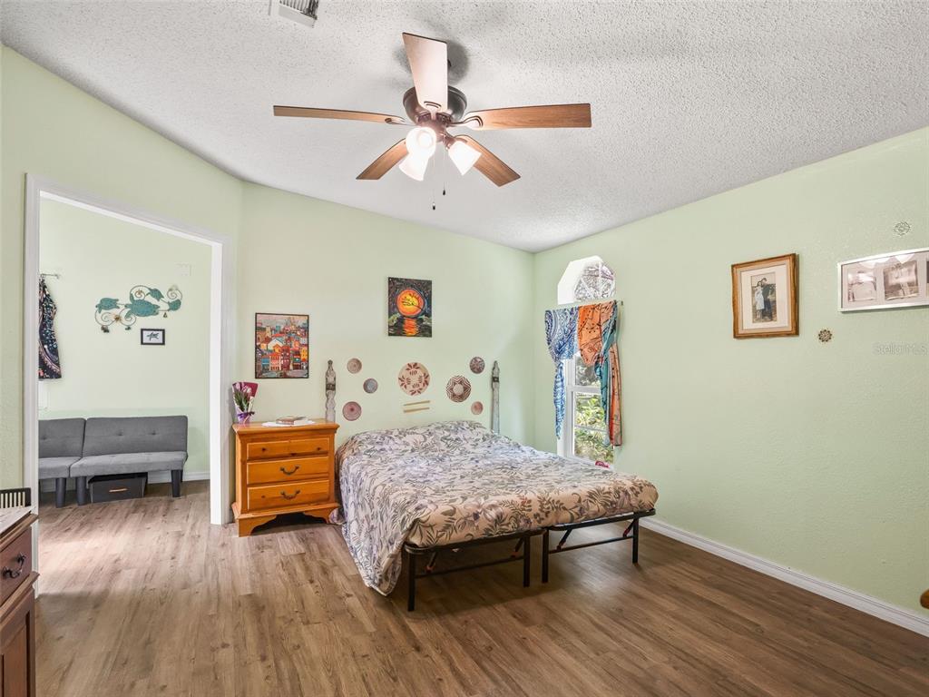 17090 Southeast 173rd Terrace Road Weirsdale, FL 32195 - Photo 16 of 54 a bedroom with furniture and a wooden floor