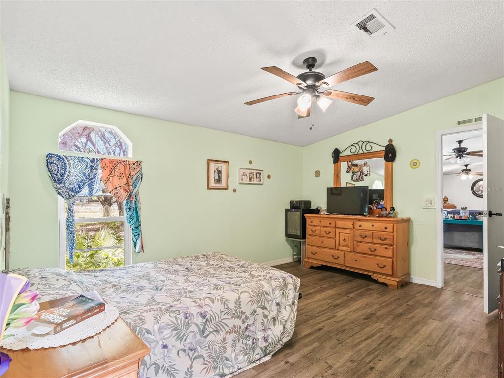 17090 Southeast 173rd Terrace Road Weirsdale, FL 32195 - Photo 17 of 54 a bed room with a bed and a chandelier