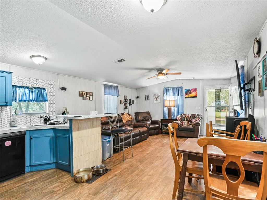 17090 Southeast 173rd Terrace Road Weirsdale, FL 32195 - Photo 33 of 54 a very nice looking open dining room with kitchen island a stove a sink a dining table and chairs