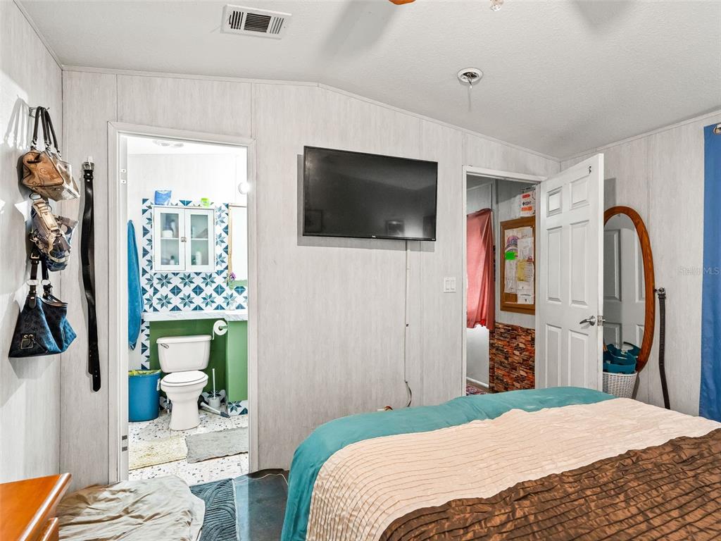 17090 Southeast 173rd Terrace Road Weirsdale, FL 32195 - Photo 35 of 54 a bedroom with a bed and a flat screen tv