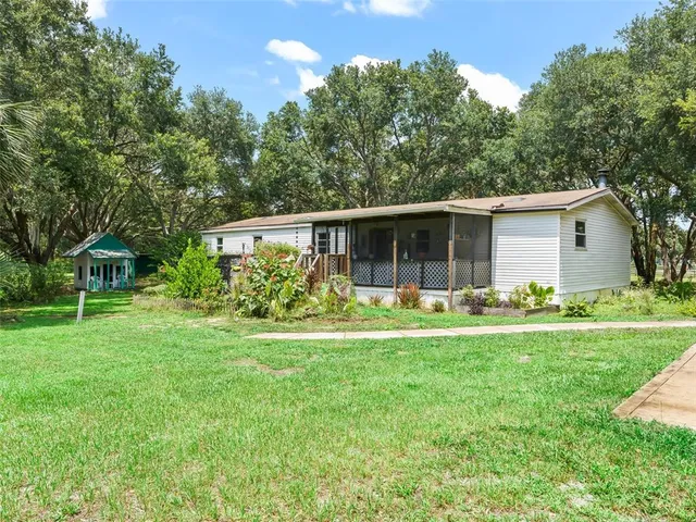 a front view of a house with a garden and trees