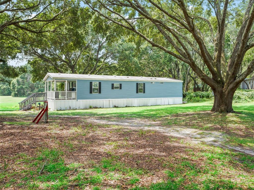17090 Southeast 173rd Terrace Road Weirsdale, FL 32195 - Photo 45 of 54 a view of a house with backyard and trees