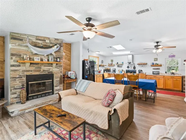 a living room with furniture kitchen view and a fireplace