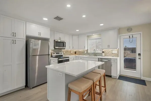 a kitchen with a refrigerator a sink and cabinets