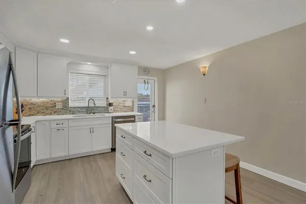 a kitchen with a sink cabinets and wooden floor