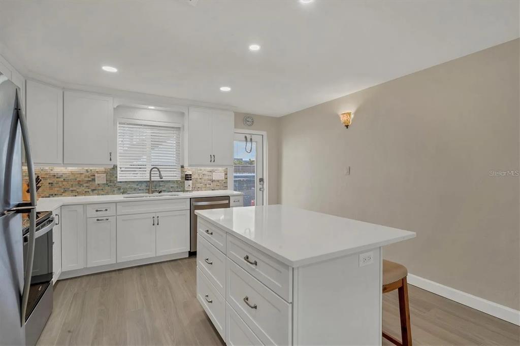 6006 Midnight Pass Road, Unit 36 Sarasota, FL 34242 - Photo 12 of 43 a kitchen with a sink cabinets and wooden floor