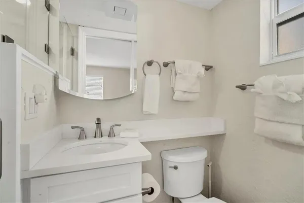 a bathroom with a sink toilet and mirror
