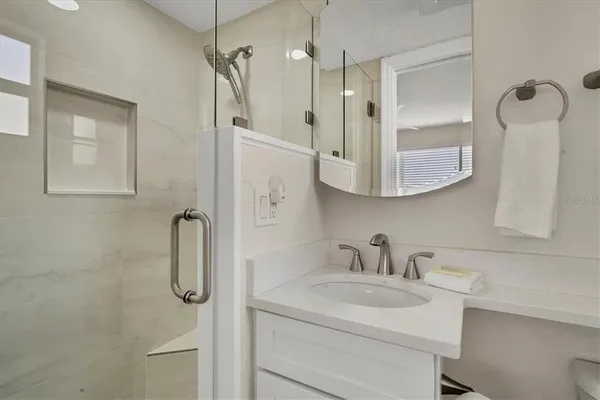 a bathroom with a sink a toilet and shower