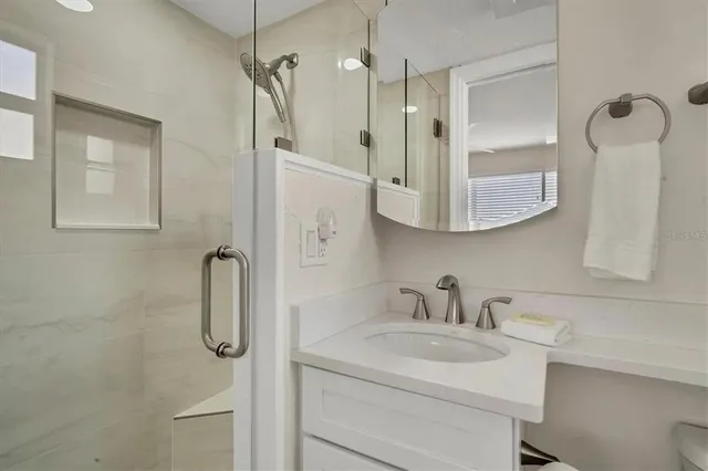 a bathroom with a sink a toilet and shower