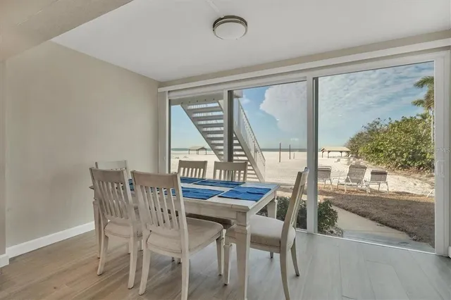 a view of a dining room with furniture large windows and wooden floor
