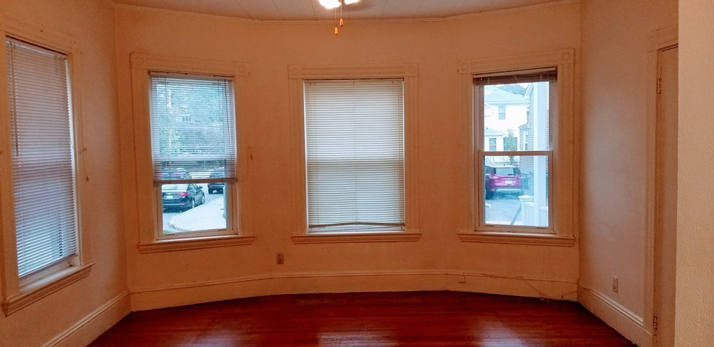 58 Dearborn Street Medford, MA 02155 - Photo 22 of 30 a view of an empty room with wooden floor and windows