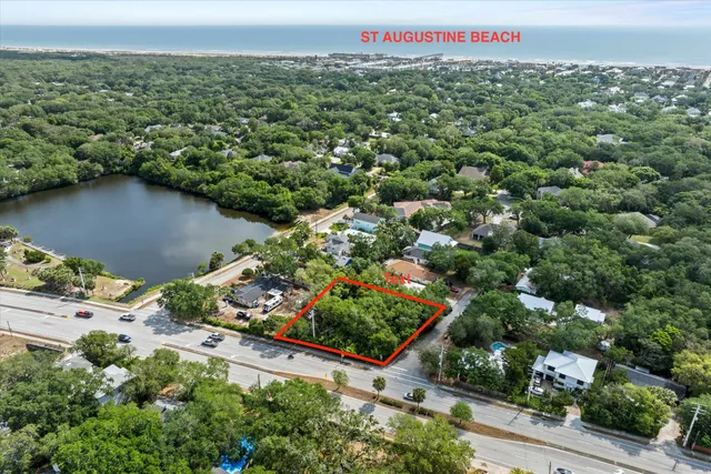 an aerial view of a houses with a yard and lake view