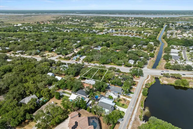an aerial view of residential houses with outdoor space and trees