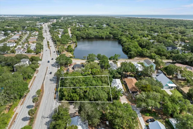 an aerial view of a house with a yard and lake view