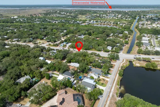 an aerial view of residential houses with outdoor space and trees
