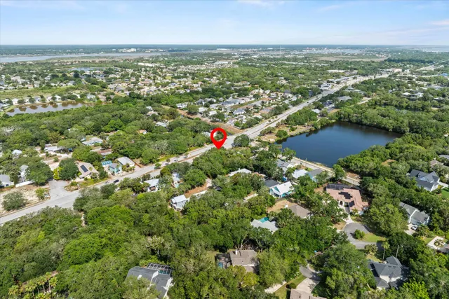 an aerial view of residential houses with outdoor space and trees
