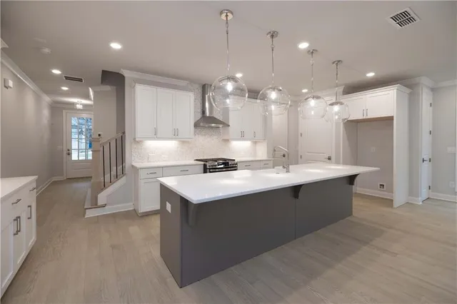 a view of a kitchen with kitchen island a sink stainless steel appliances and a counter top