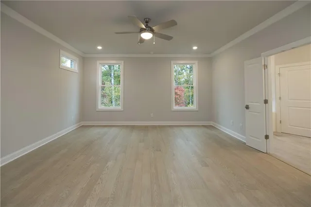 an empty room with closet and a ceiling fan