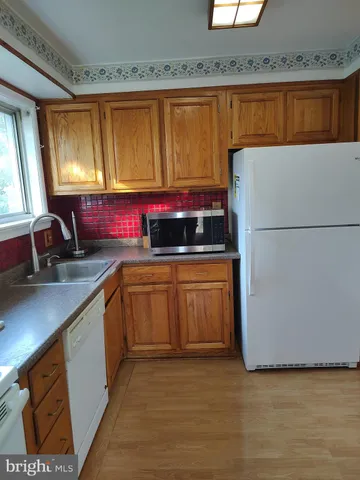 a kitchen with granite countertop a sink a counter space and cabinets