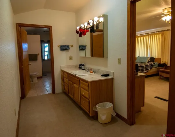 a en suite bathroom with a granite countertop sink and a mirror