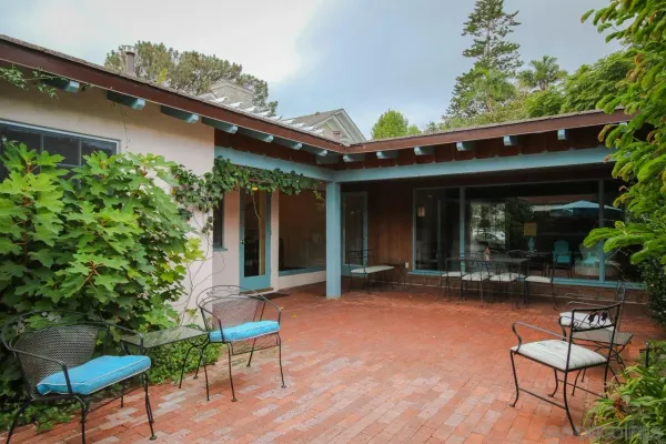 a view of a chair and table in backyard of the house