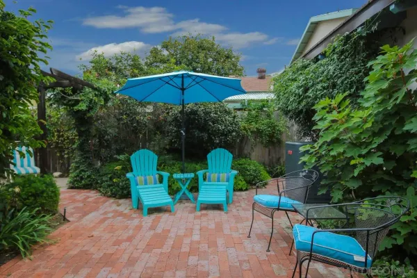 a view of backyard with two chairs and a umbrella