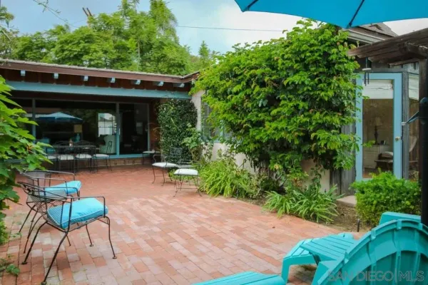 a view of a chair and table in backyard of the house