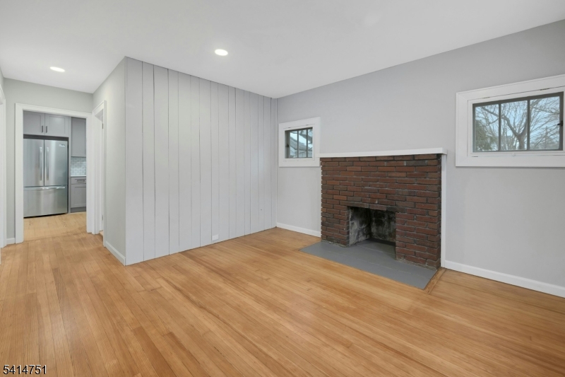 173 Runnymede Road West Caldwell, NJ 07006 - Photo 12 of 27 a view of an empty room with wooden floor fireplace and a window