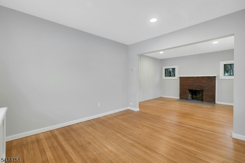 173 Runnymede Road West Caldwell, NJ 07006 - Photo 13 of 27 a view of empty room with wooden floor and fireplace