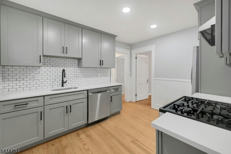 173 Runnymede Road West Caldwell, NJ 07006 - Photo 3 of 27 a kitchen with granite countertop a sink stove and cabinets