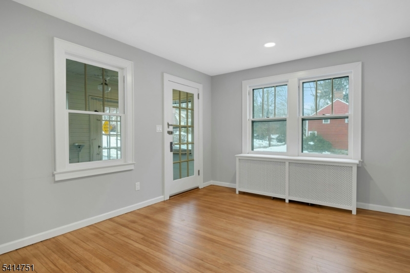 173 Runnymede Road West Caldwell, NJ 07006 - Photo 10 of 27 an empty room with wooden floor and windows