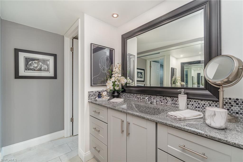 25806 Cockleshell Drive, Unit 115 Bonita Springs, FL 34135 - Photo 11 of 25 a bathroom with a granite countertop sink and a mirror
