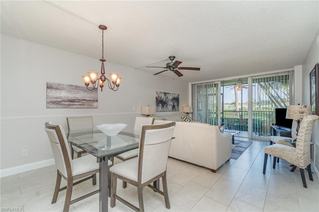 25806 Cockleshell Drive, Unit 115 Bonita Springs, FL 34135 - Photo 3 of 25 a view of a dining room with furniture wooden floor and chandelier