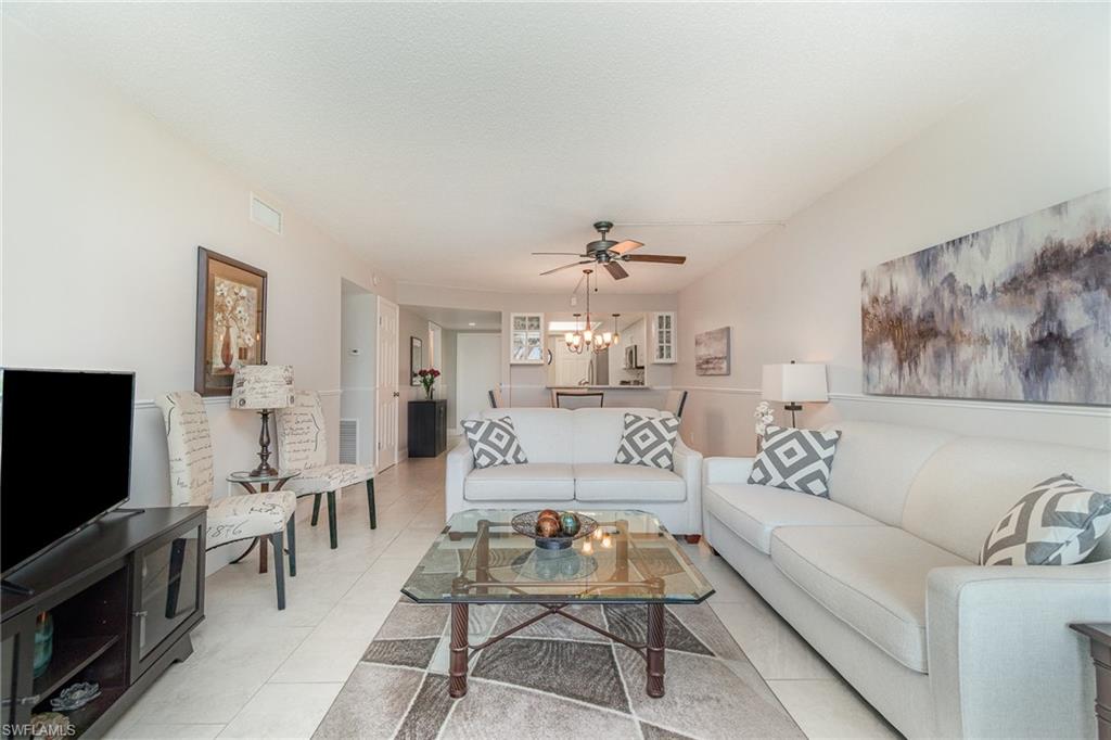 25806 Cockleshell Drive, Unit 115 Bonita Springs, FL 34135 - Photo 4 of 25 a living room with furniture and a flat screen tv