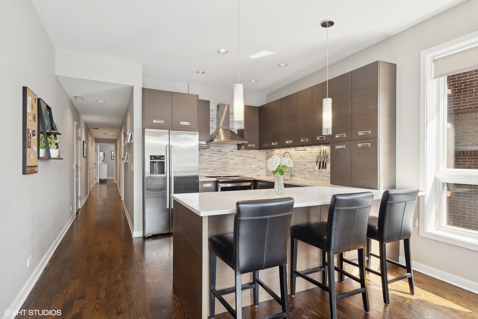 2136 West North Avenue, Unit 2E Chicago, IL 60647 - Photo 9 of 22 a kitchen with stainless steel appliances a dining table chairs refrigerator and sink