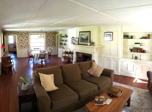 a living room with furniture fireplace and a large window