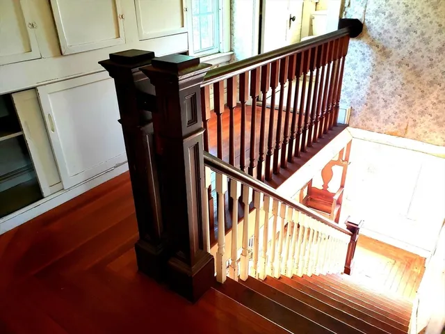 a view of staircase with railing and a window