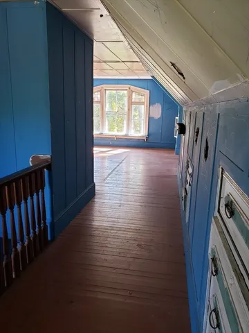 a view of a hallway with wooden floor and stairs